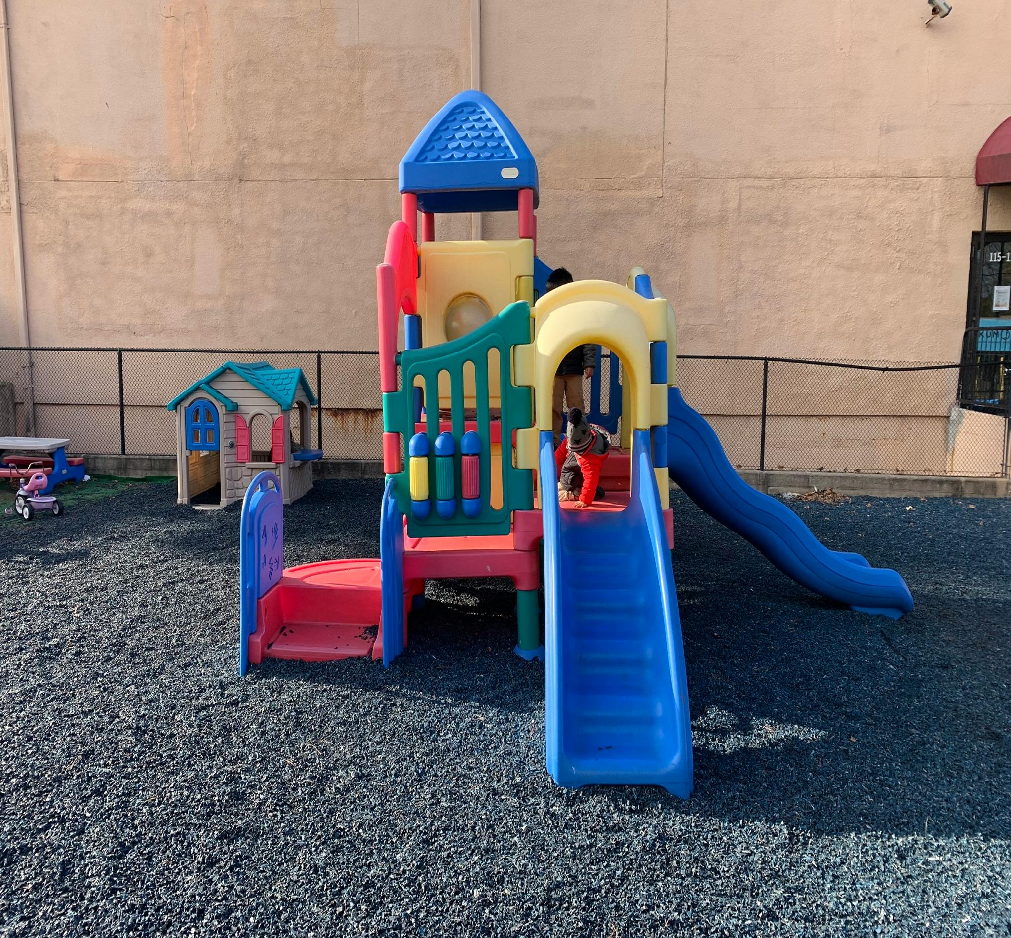 Playground structure with slides and a small playhouse