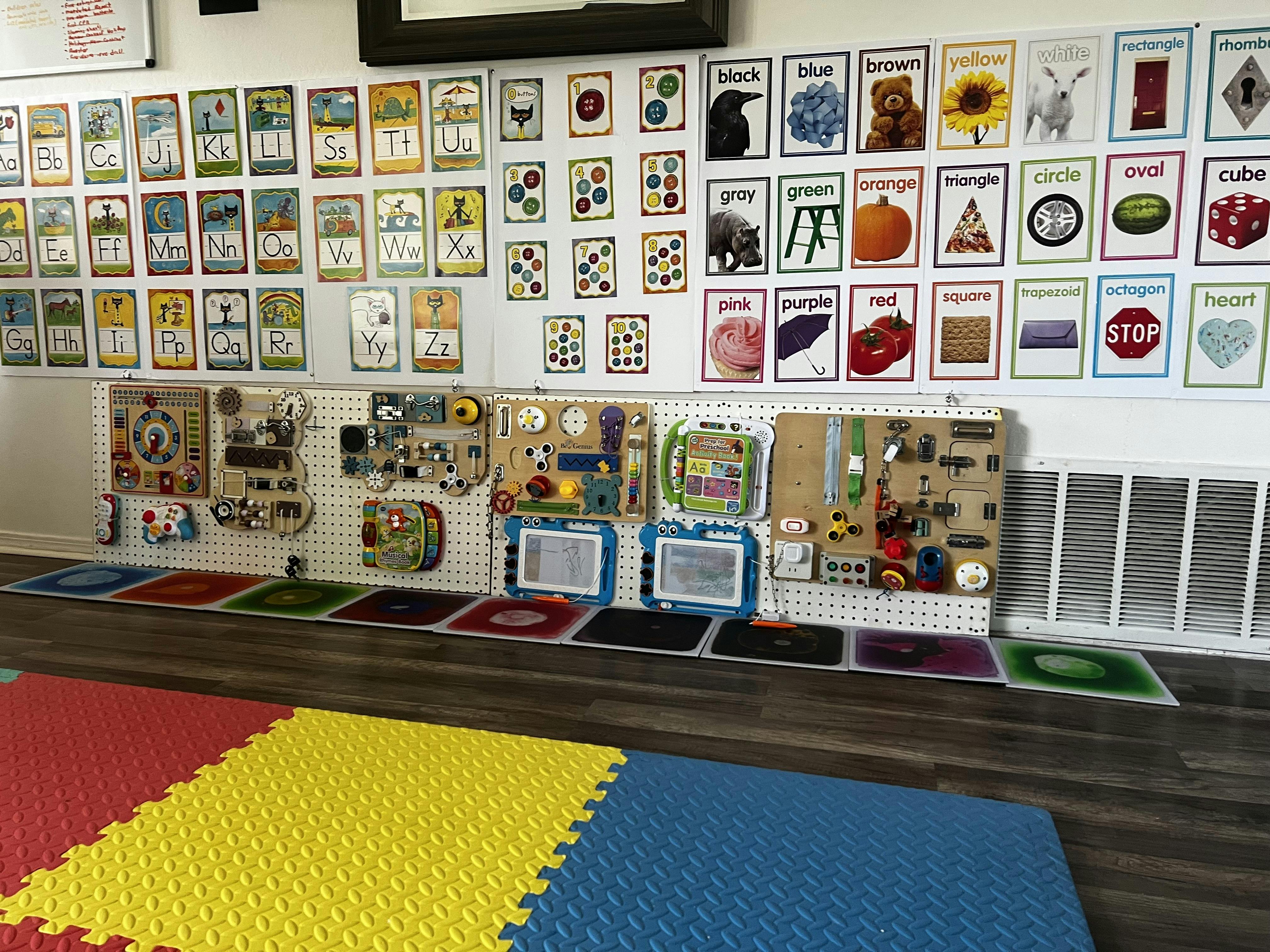 Classroom wall with educational posters and sensory activity boards