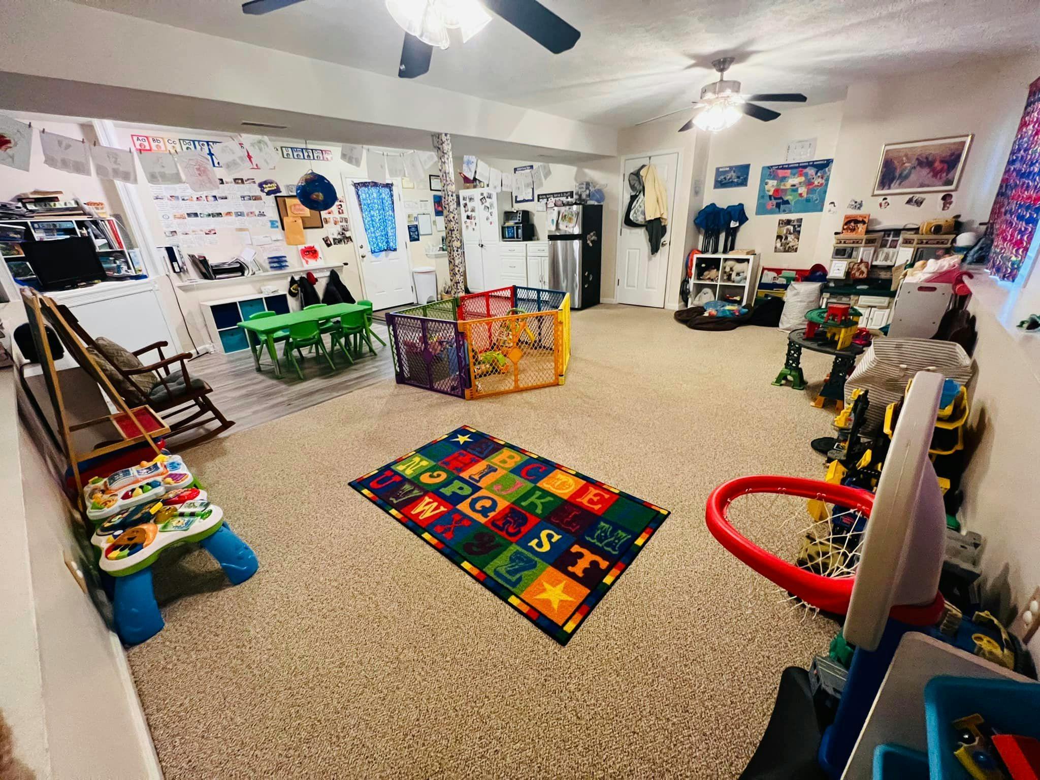 Playroom with alphabet rug, playpen, and small basketball hoop