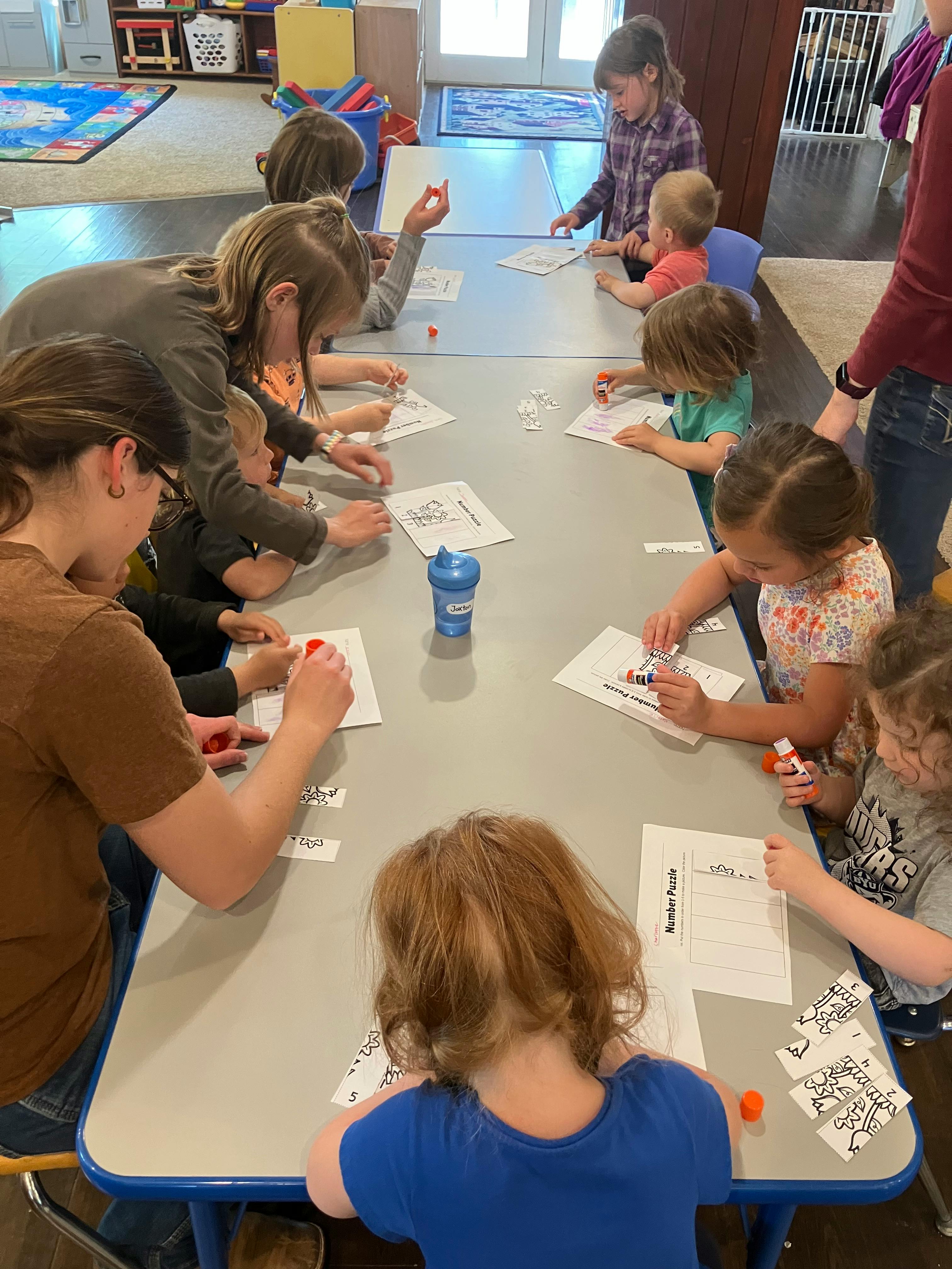 Adults and children sitting at a table doing crafts
