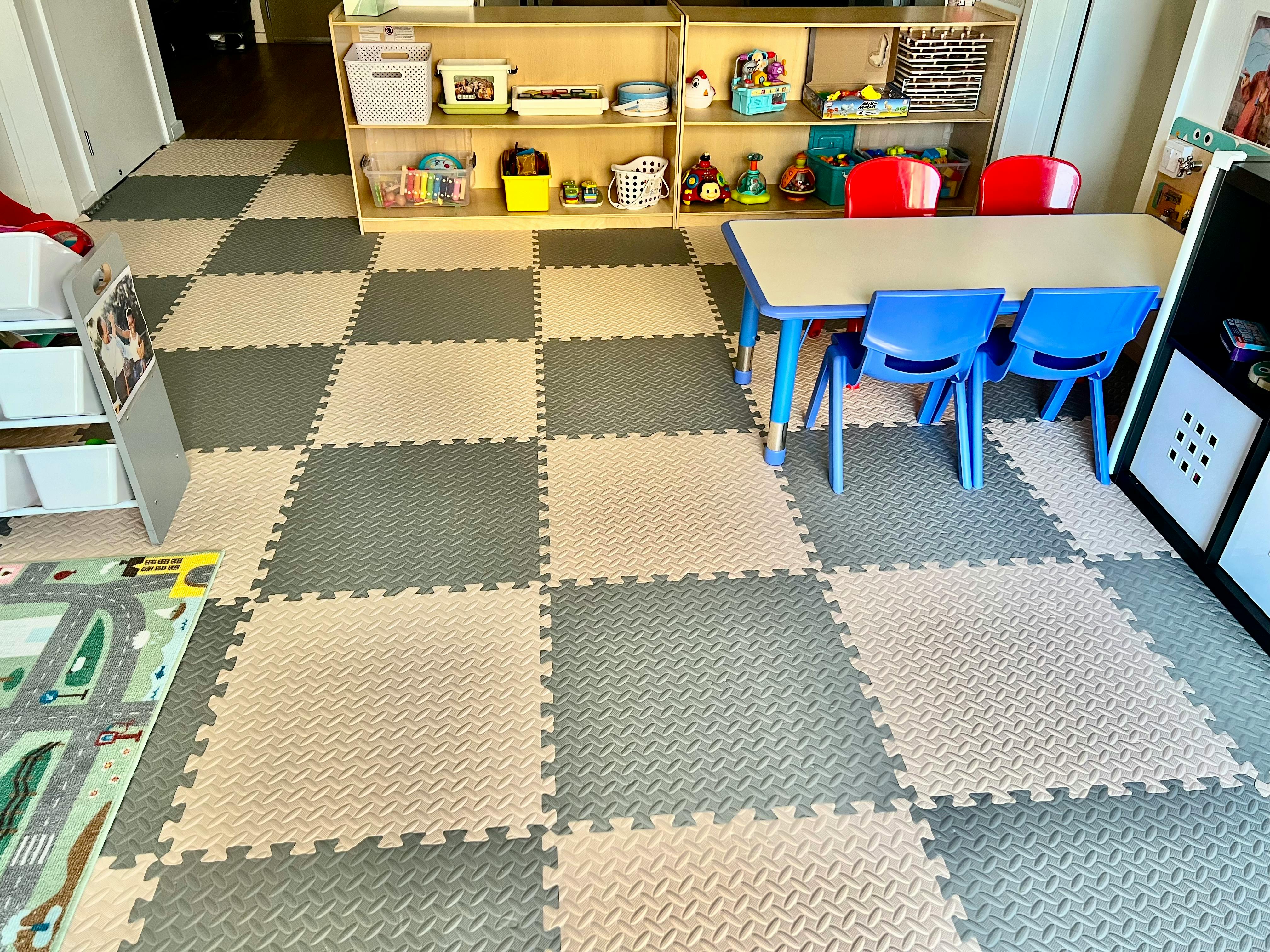 Playroom with checkered floor mats, shelves of toys, and a small table with chairs