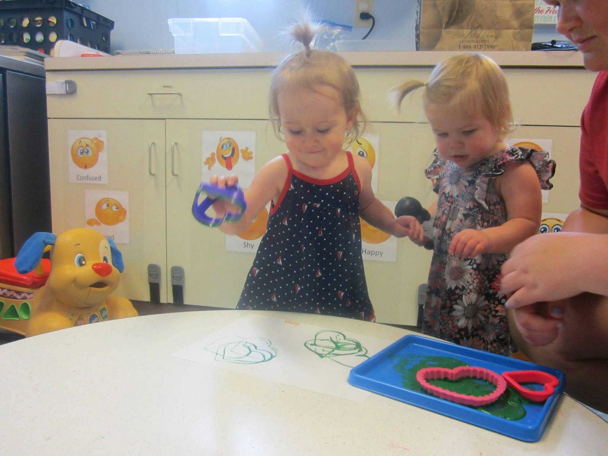 Two children playing at a table with a person