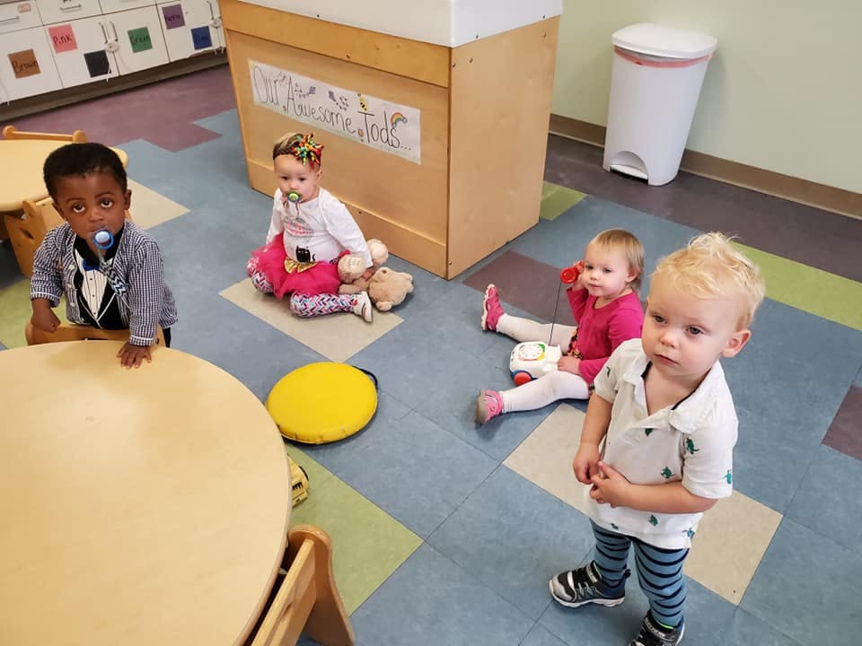 Four children in a room with a patterned floor