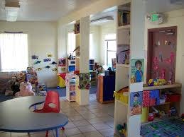 Playroom with tables, chairs, and shelves filled with toys