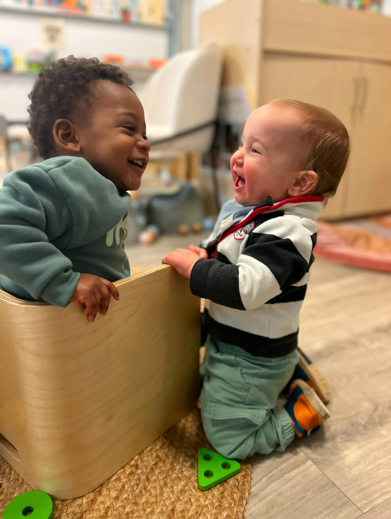 Two children playing with a wooden box
