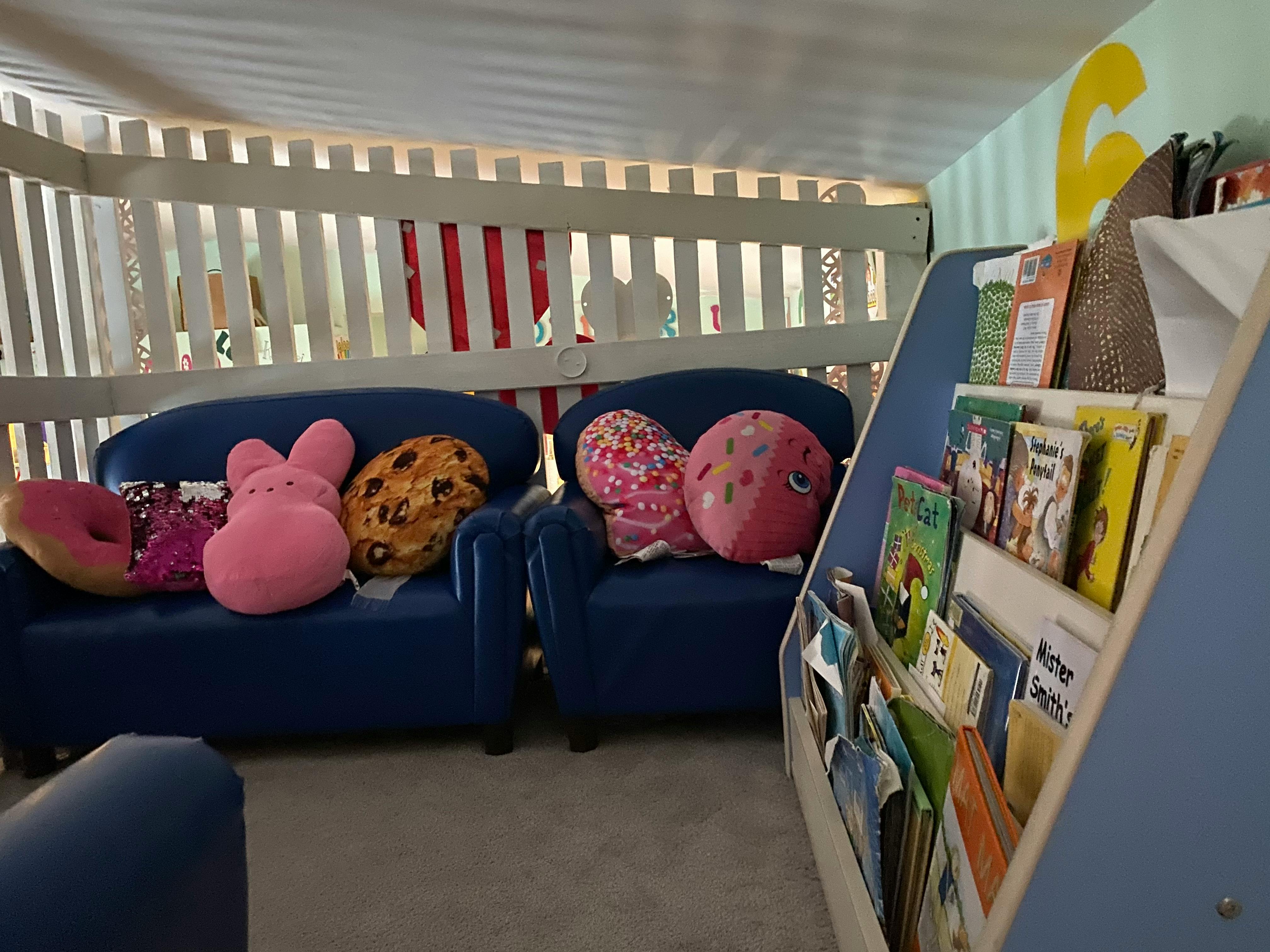 Blue couches with pillows and a bookshelf with books