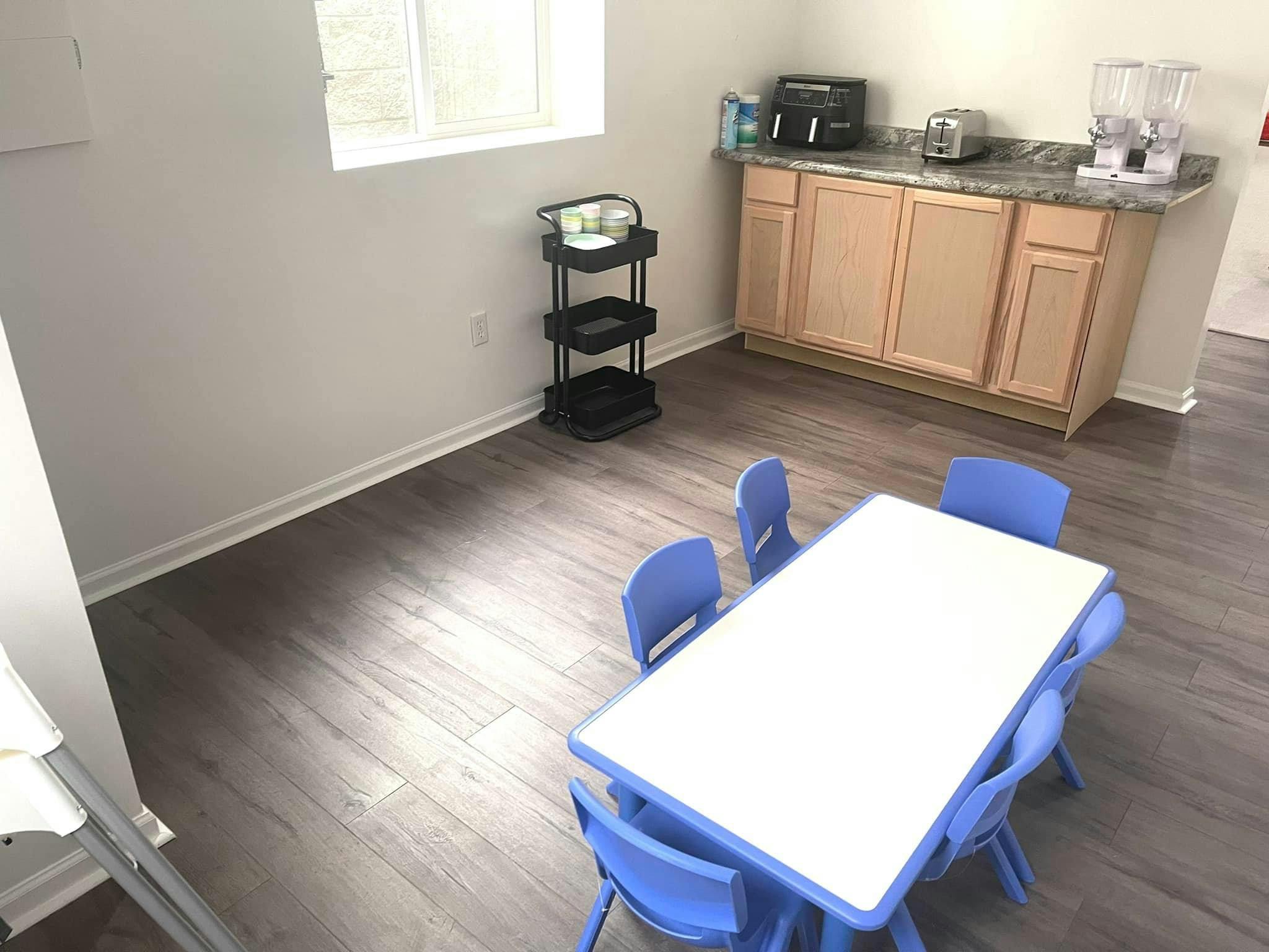 Table and chairs in a room with a counter and cabinets