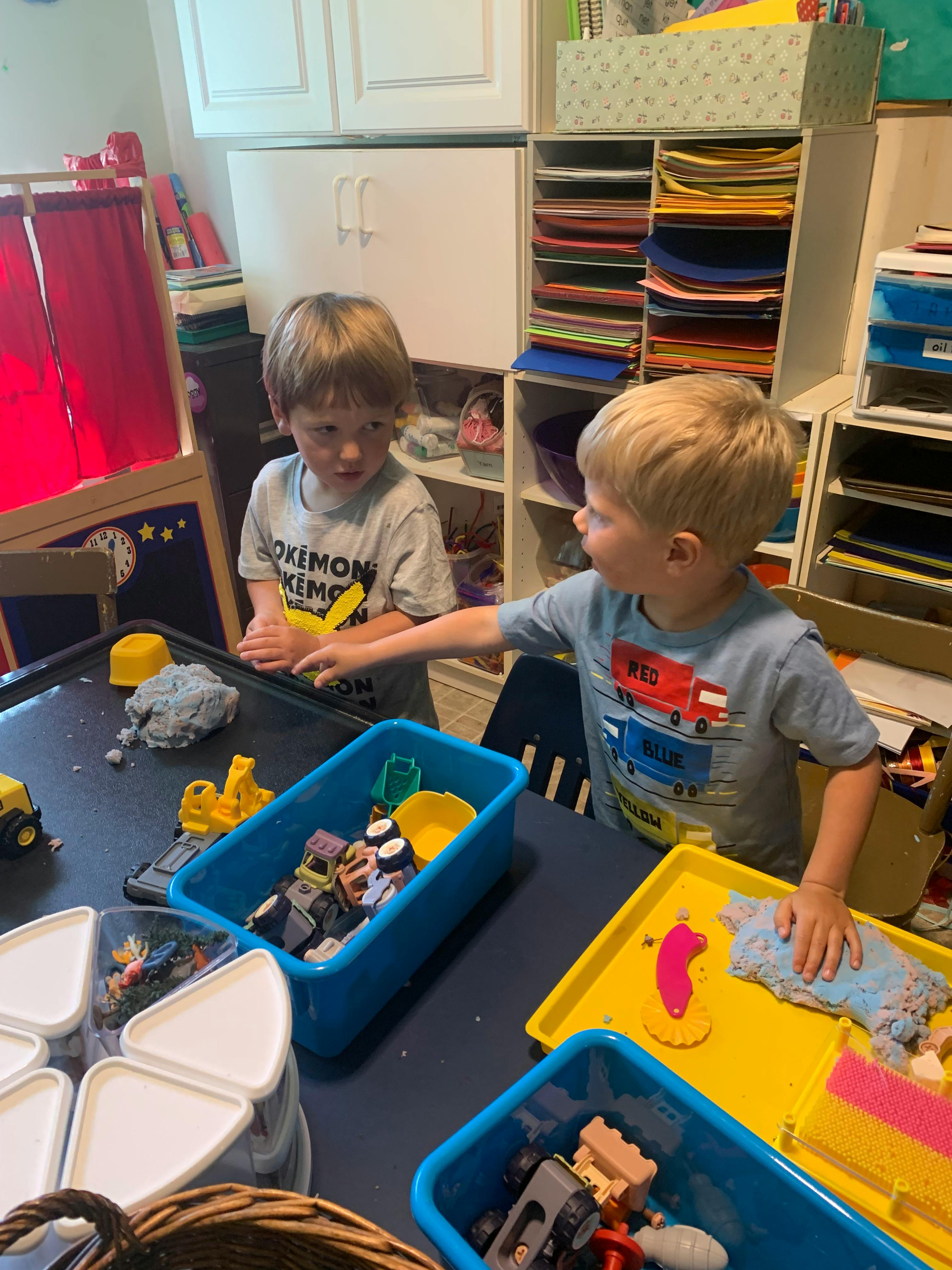 Two children playing with toys at a table