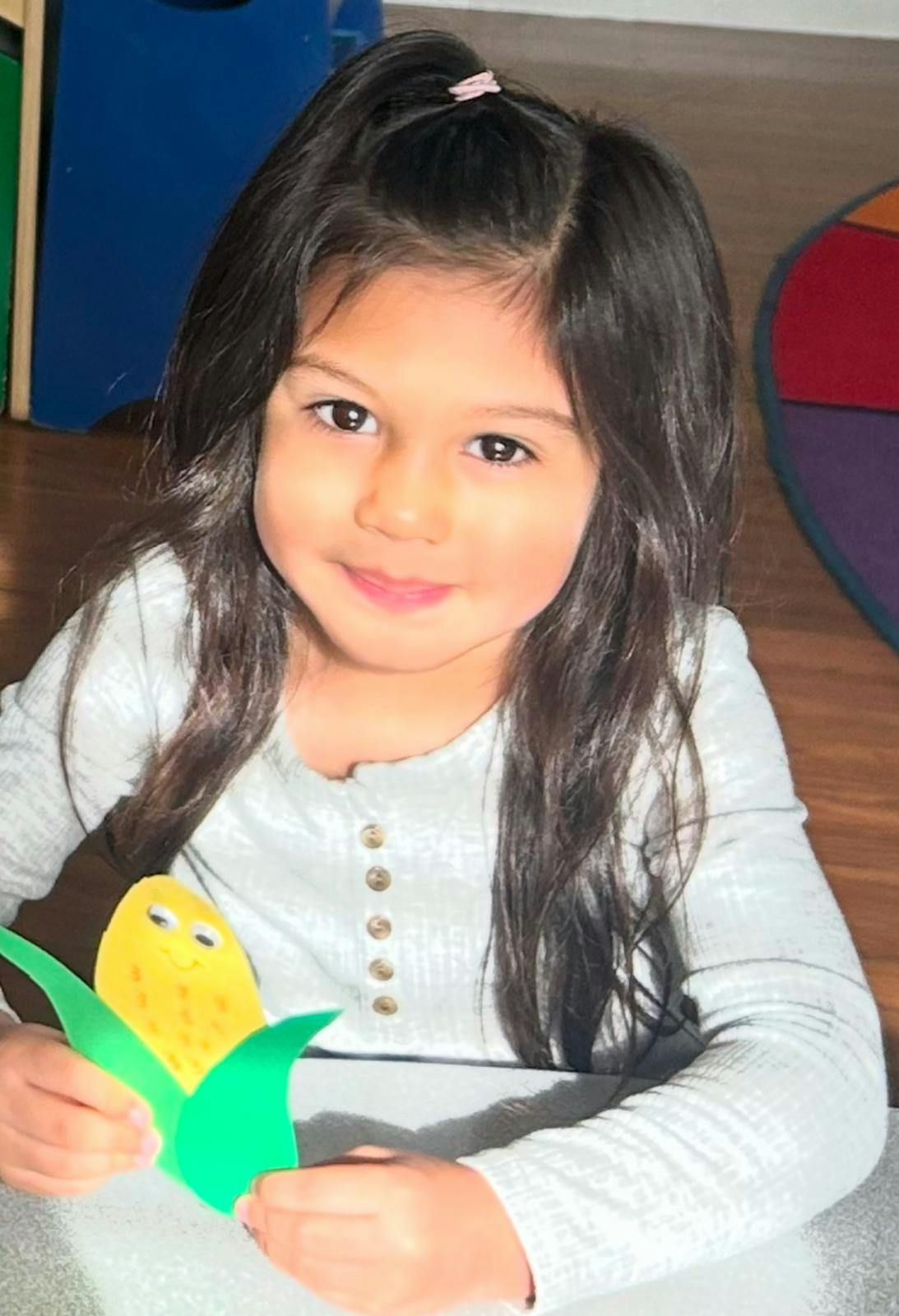Child holding a corn craft
