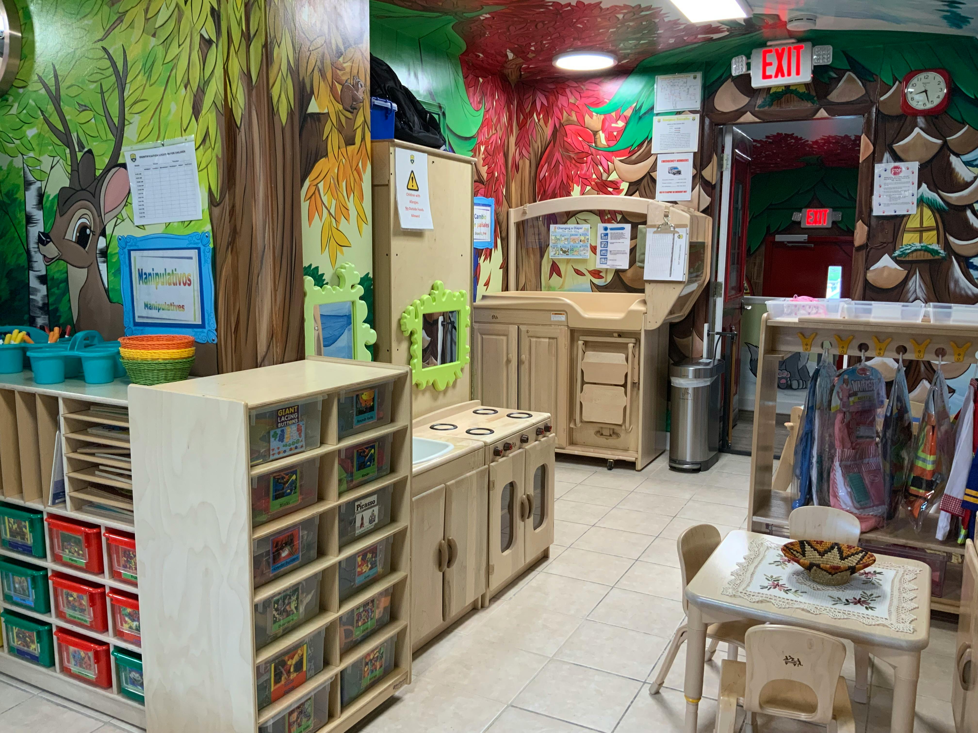 Playroom with nature-themed wall murals and child-sized furniture