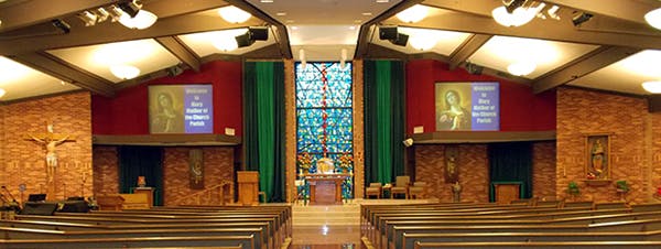 Interior of a church with pews, an altar, and stained glass