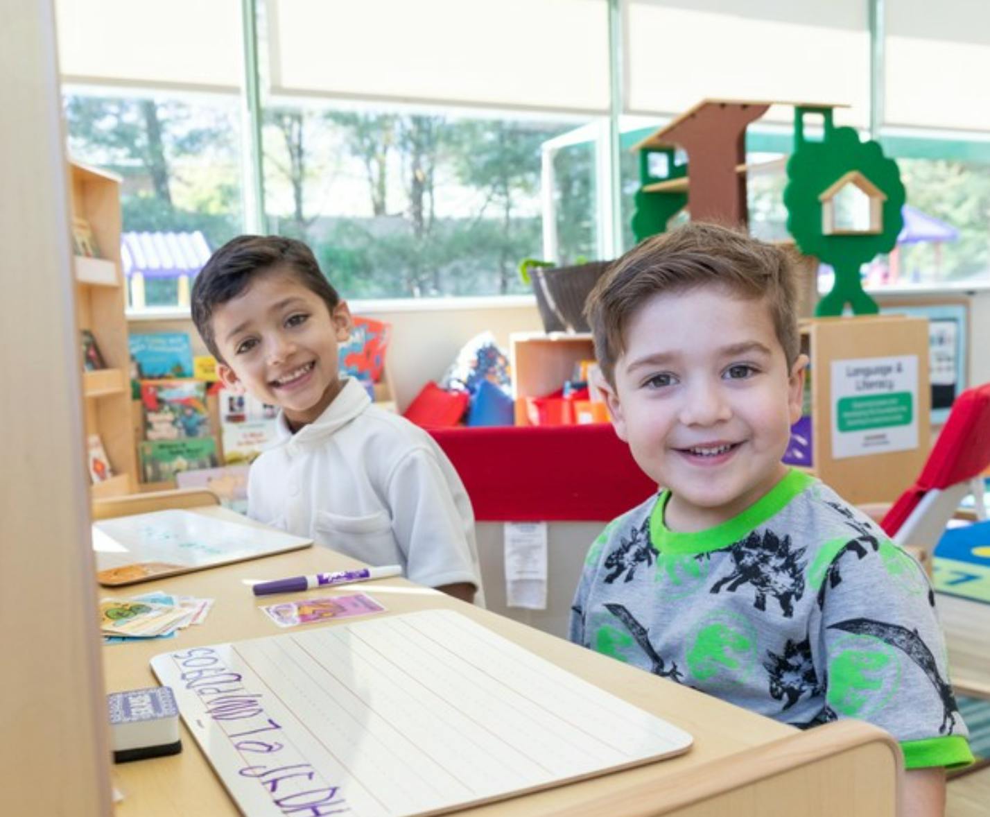 Two children sitting at a desk in a classroom