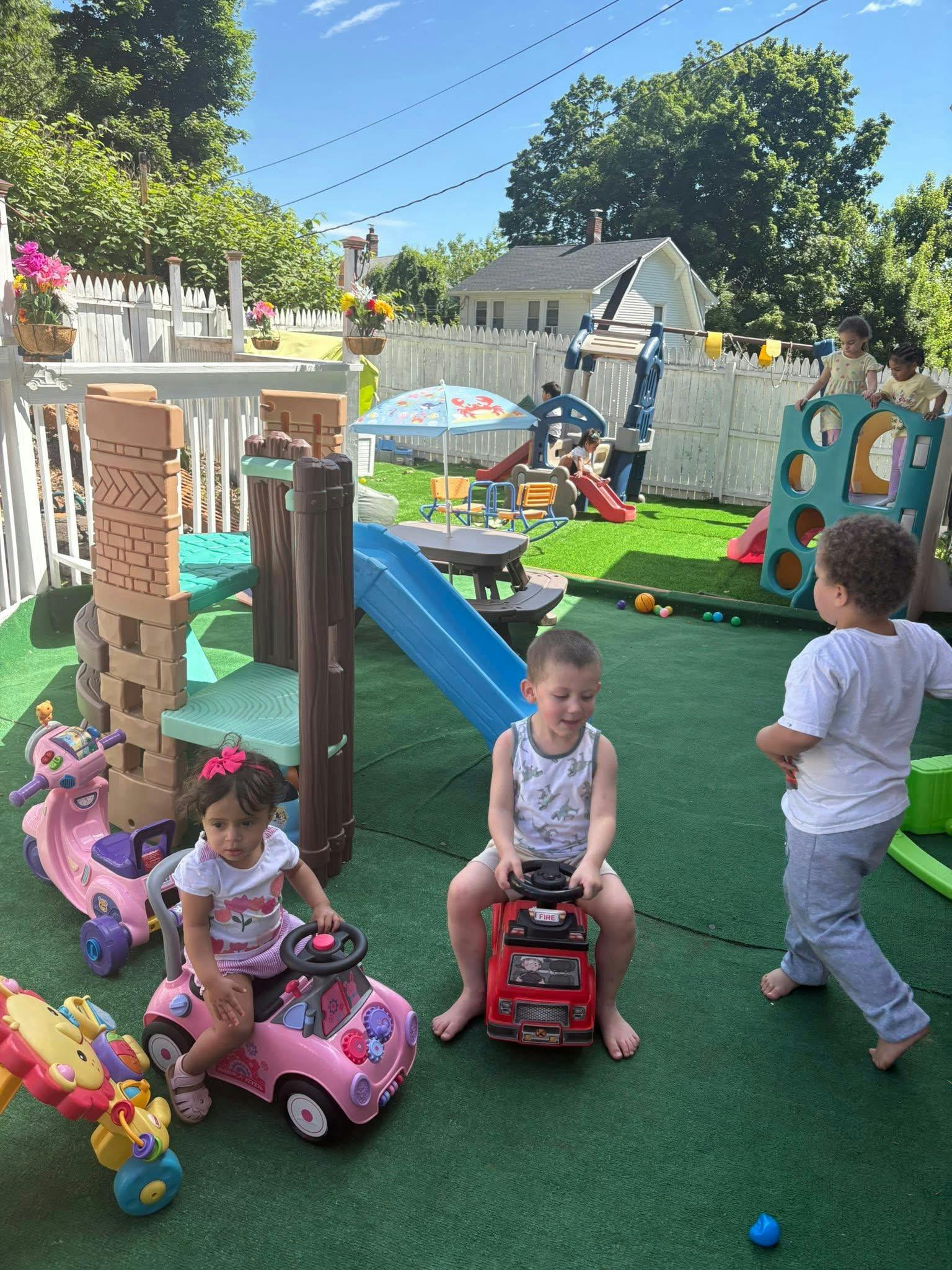 Children playing with toy vehicles on a backyard playground