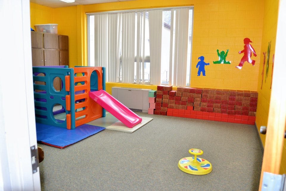 Indoor play area with a colorful climbing structure and slide