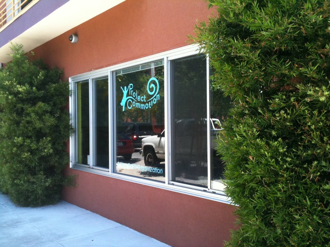Building exterior with a window decal that reads "Project Commotion"