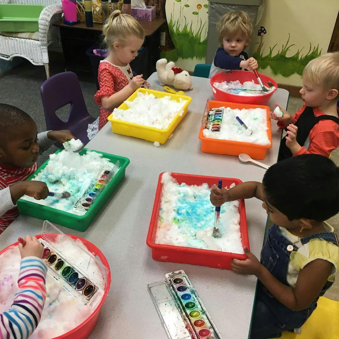 Children painting with watercolors in foam