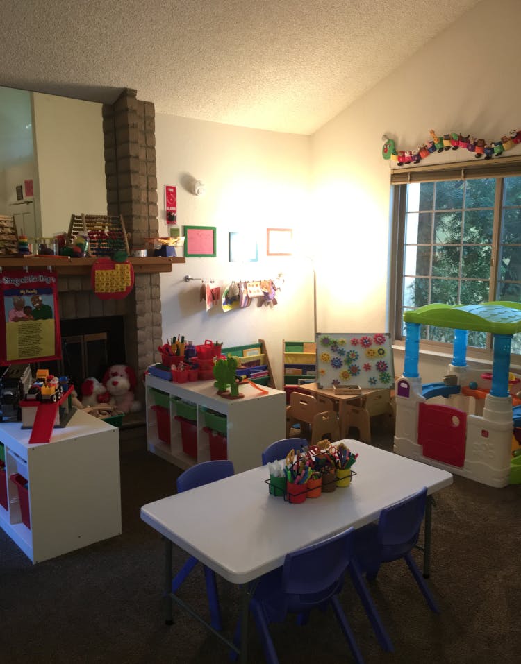 Playroom with small table and chairs, toys, and art supplies
