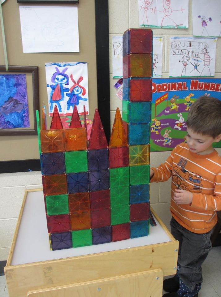 Child playing with colorful magnetic building blocks