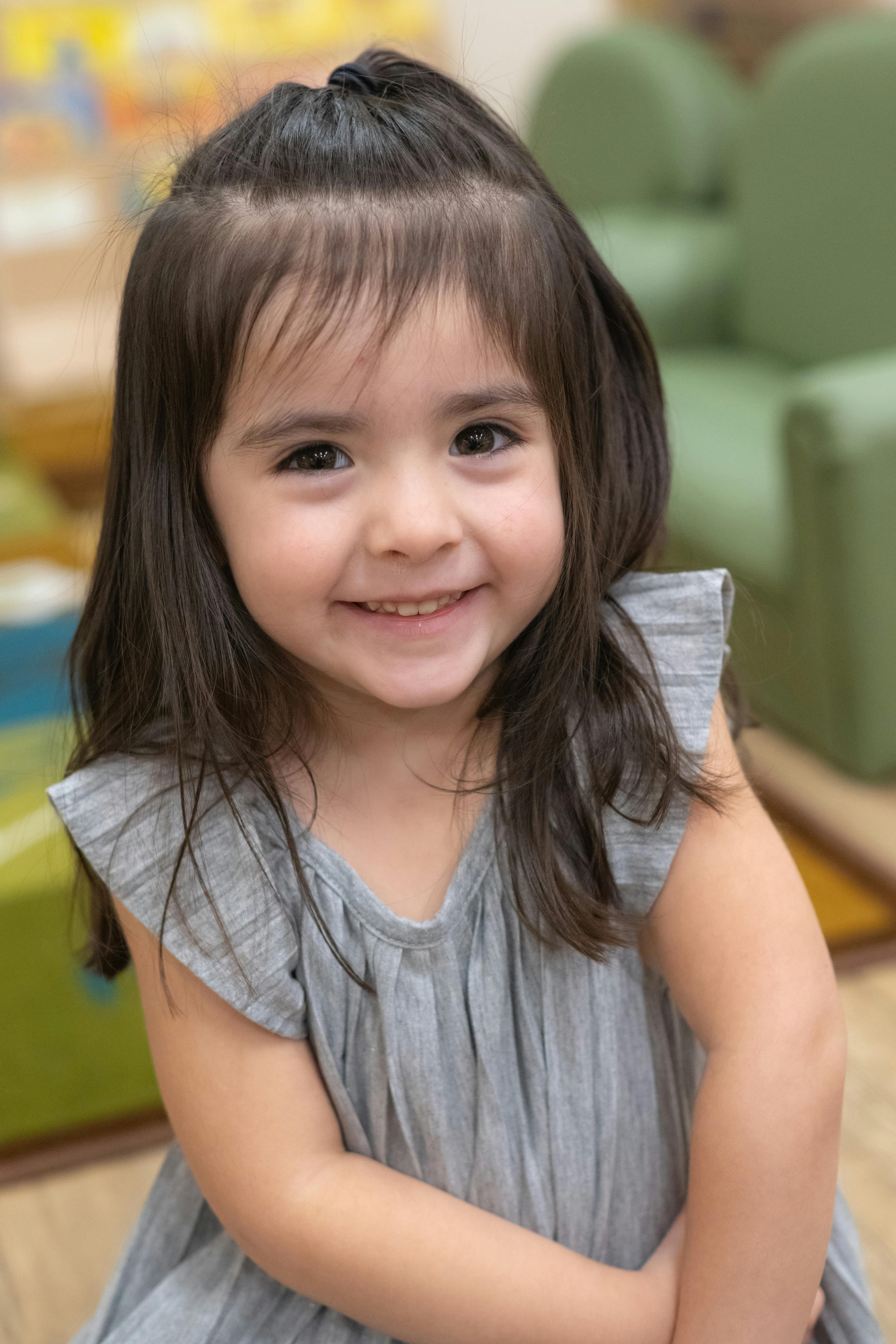 Child with long hair and bangs smiling