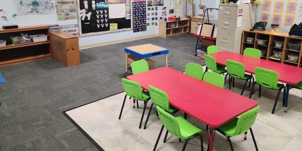 Classroom with child-sized red tables and lime green chairs