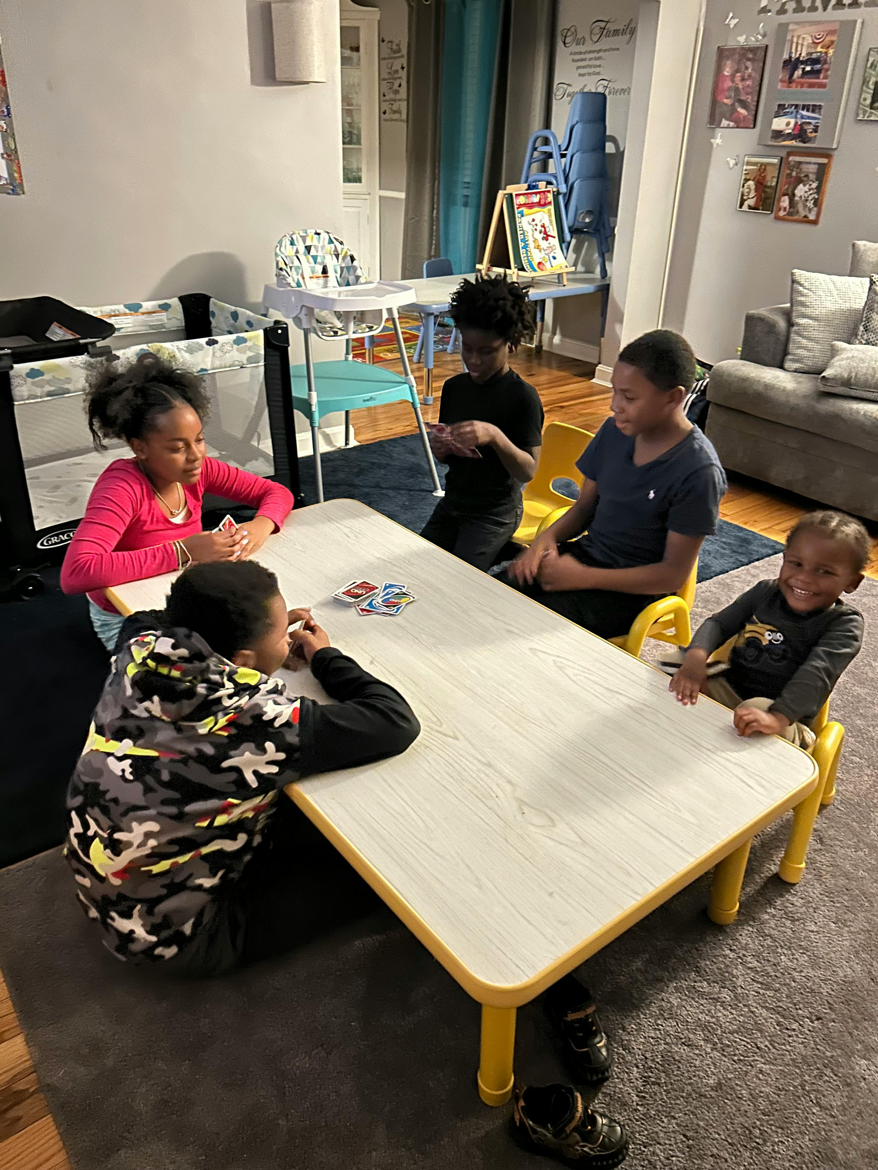 Four children playing cards at a table