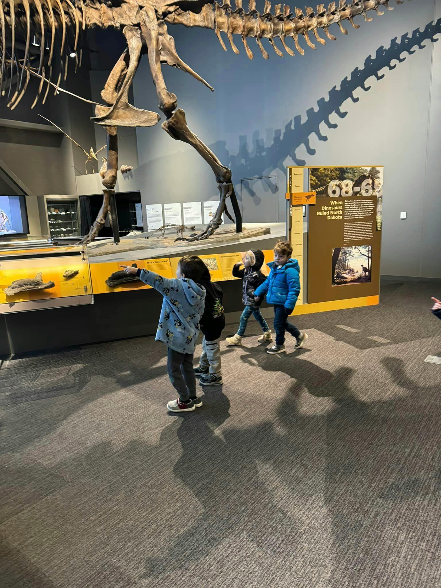 Children looking at a dinosaur skeleton in a museum