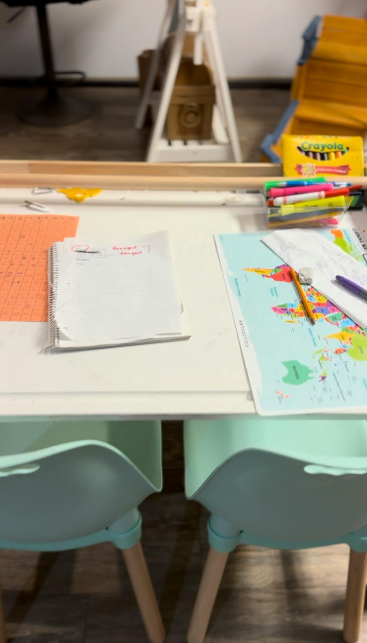 Desk with notebooks, map, and art supplies