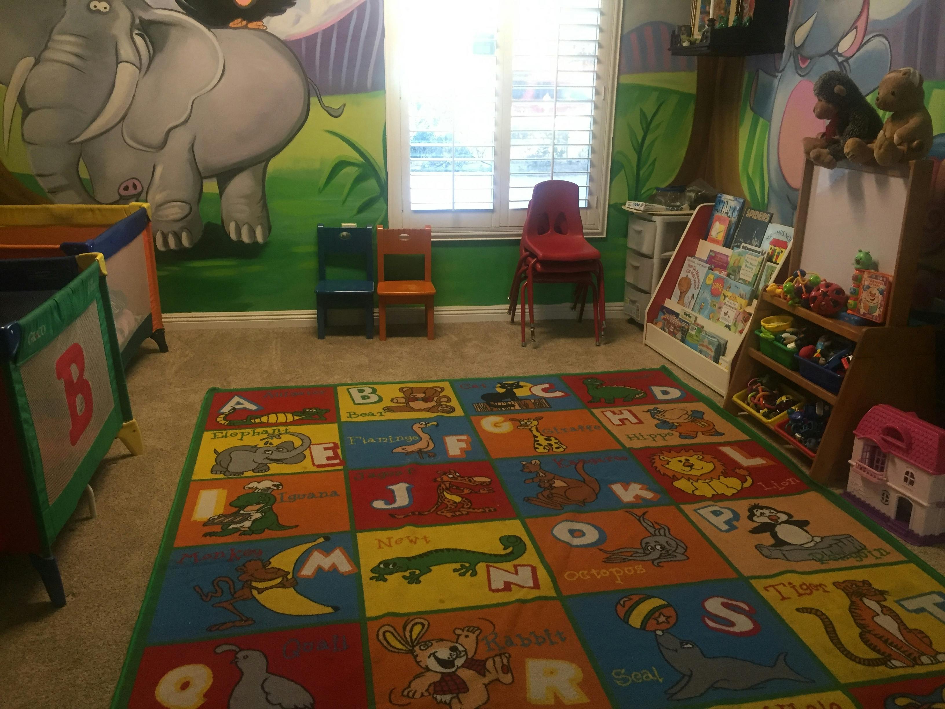 Playroom with alphabet rug, small chairs, and animal murals