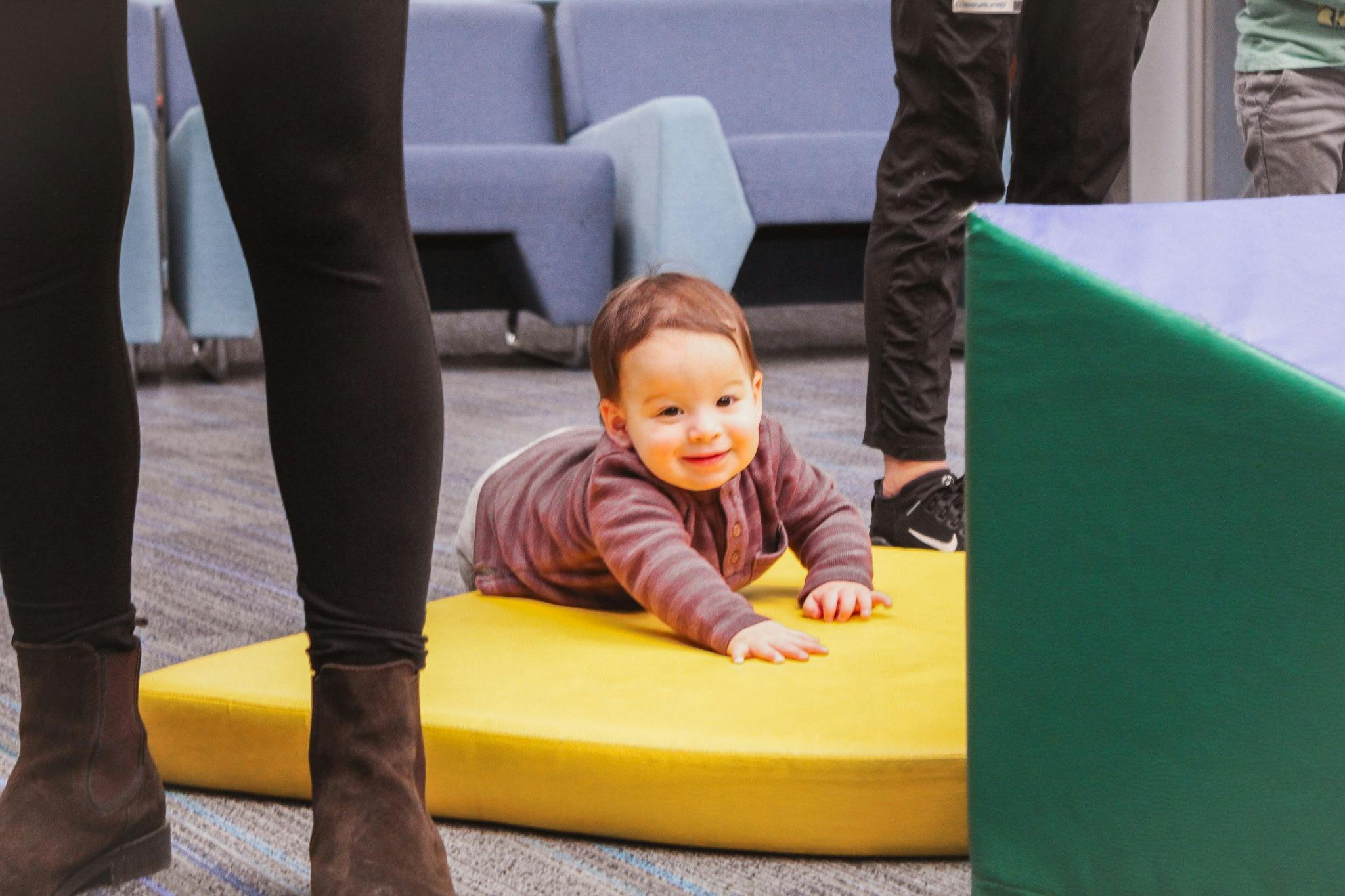 Child crawling on a yellow mat