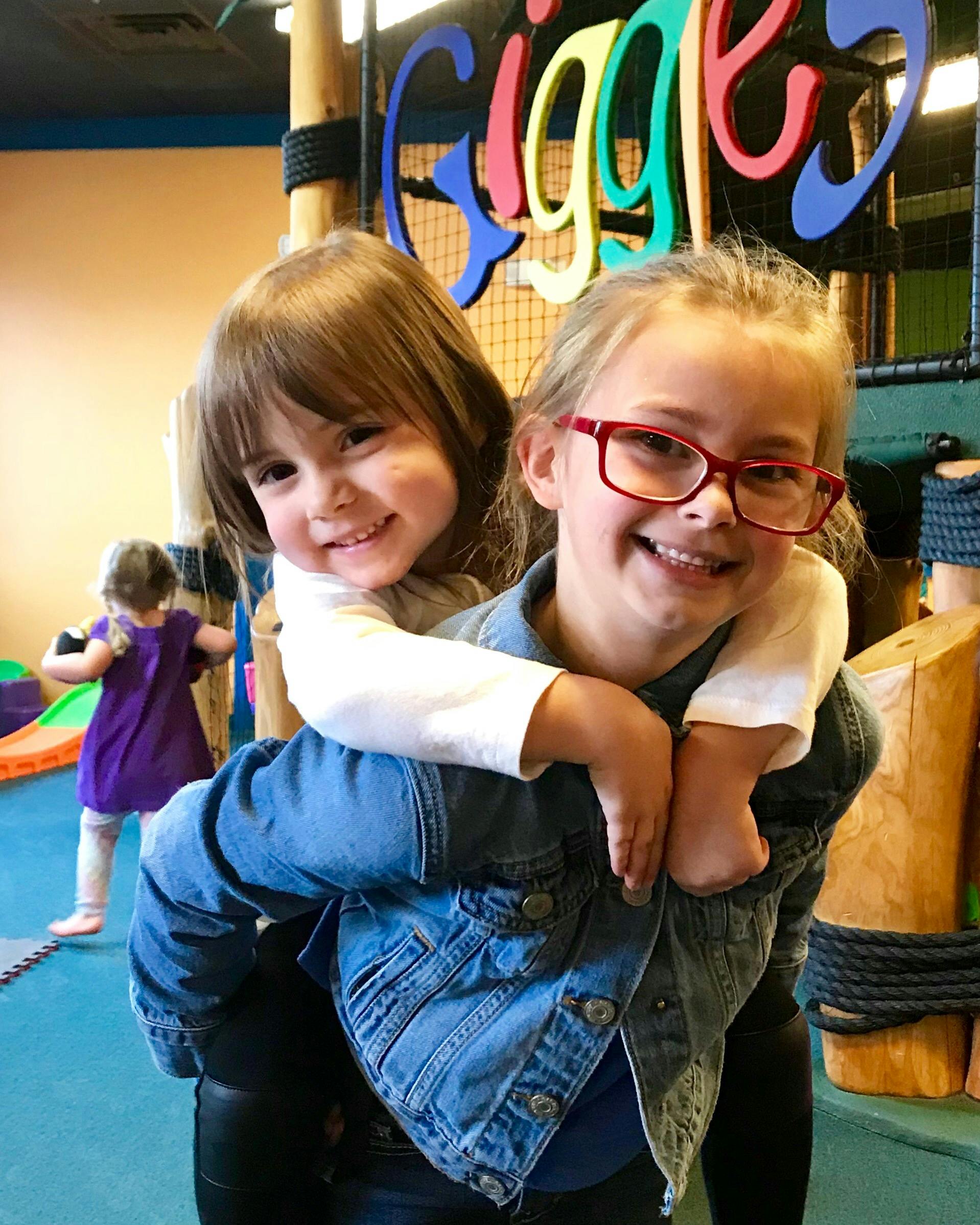 Child giving another child a piggyback ride