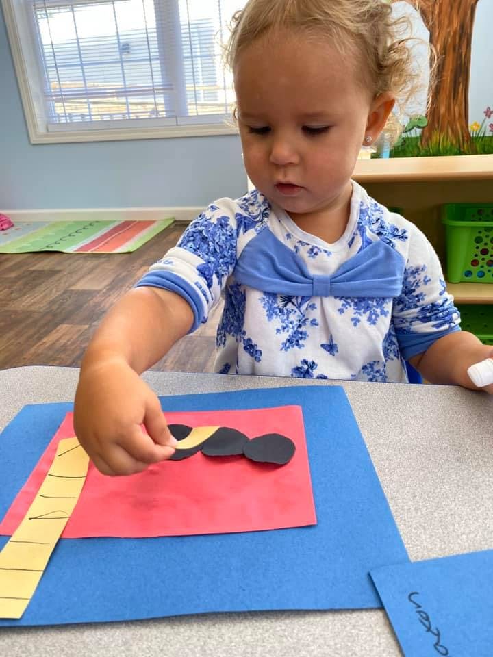 Child doing a craft with paper cutouts