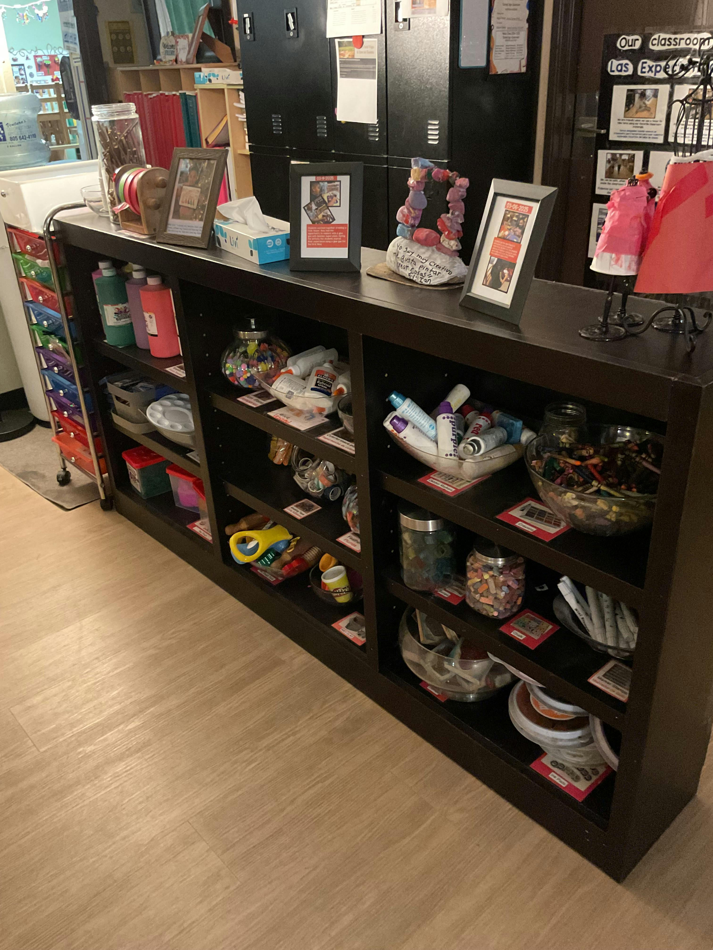 Shelves filled with various items, including bottles, jars, and framed pictures