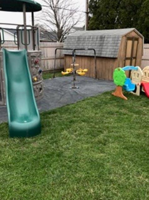 Backyard playground with slide, swings, and small shed