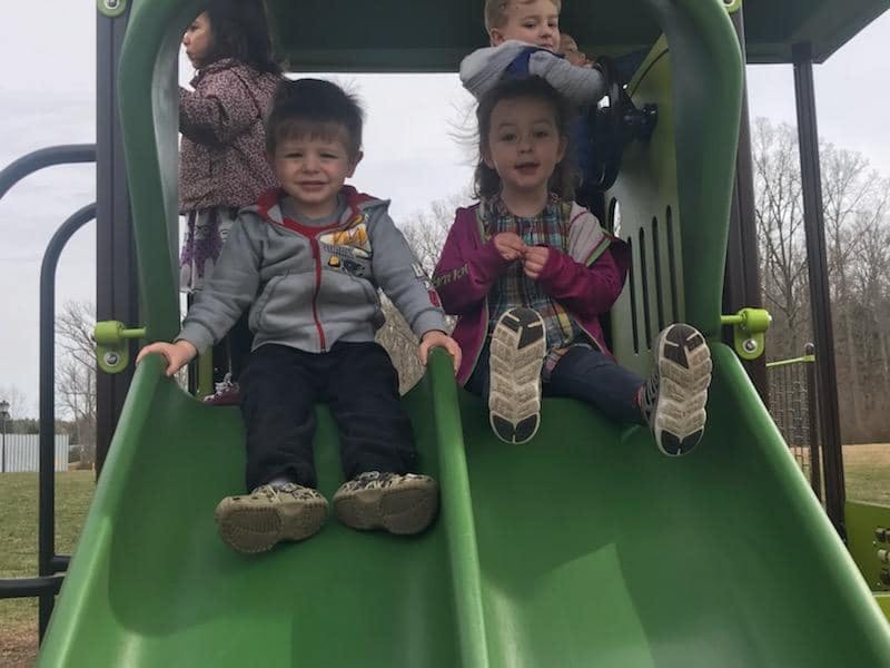 Children on a green playground slide
