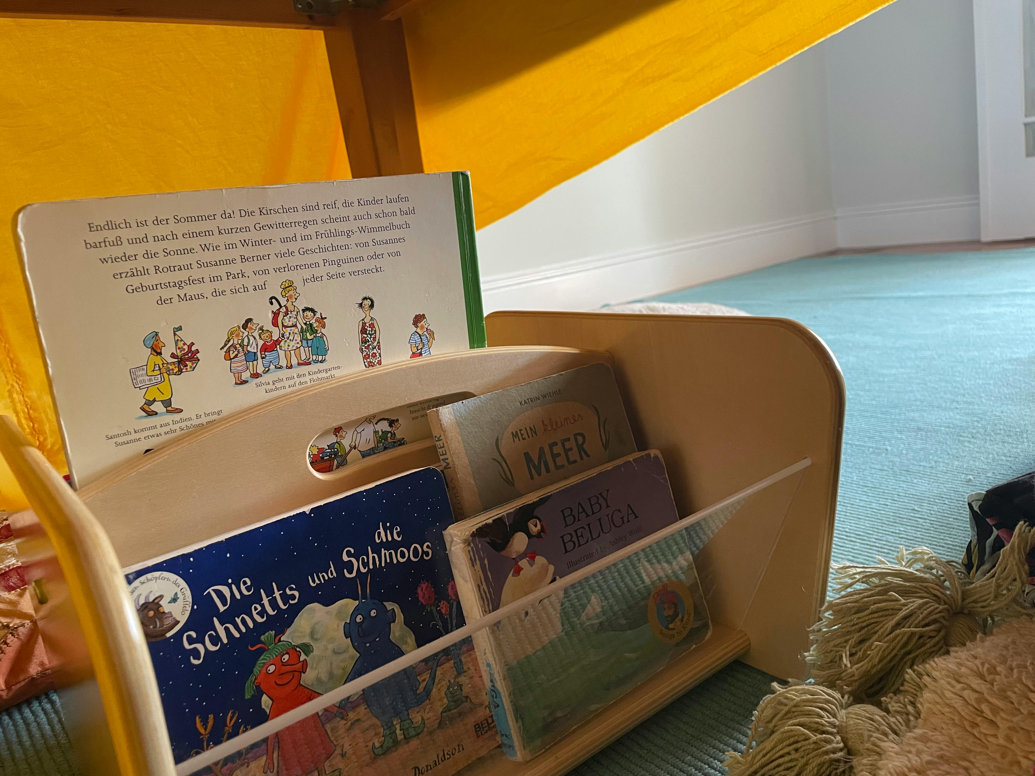 Children's books in a wooden book holder