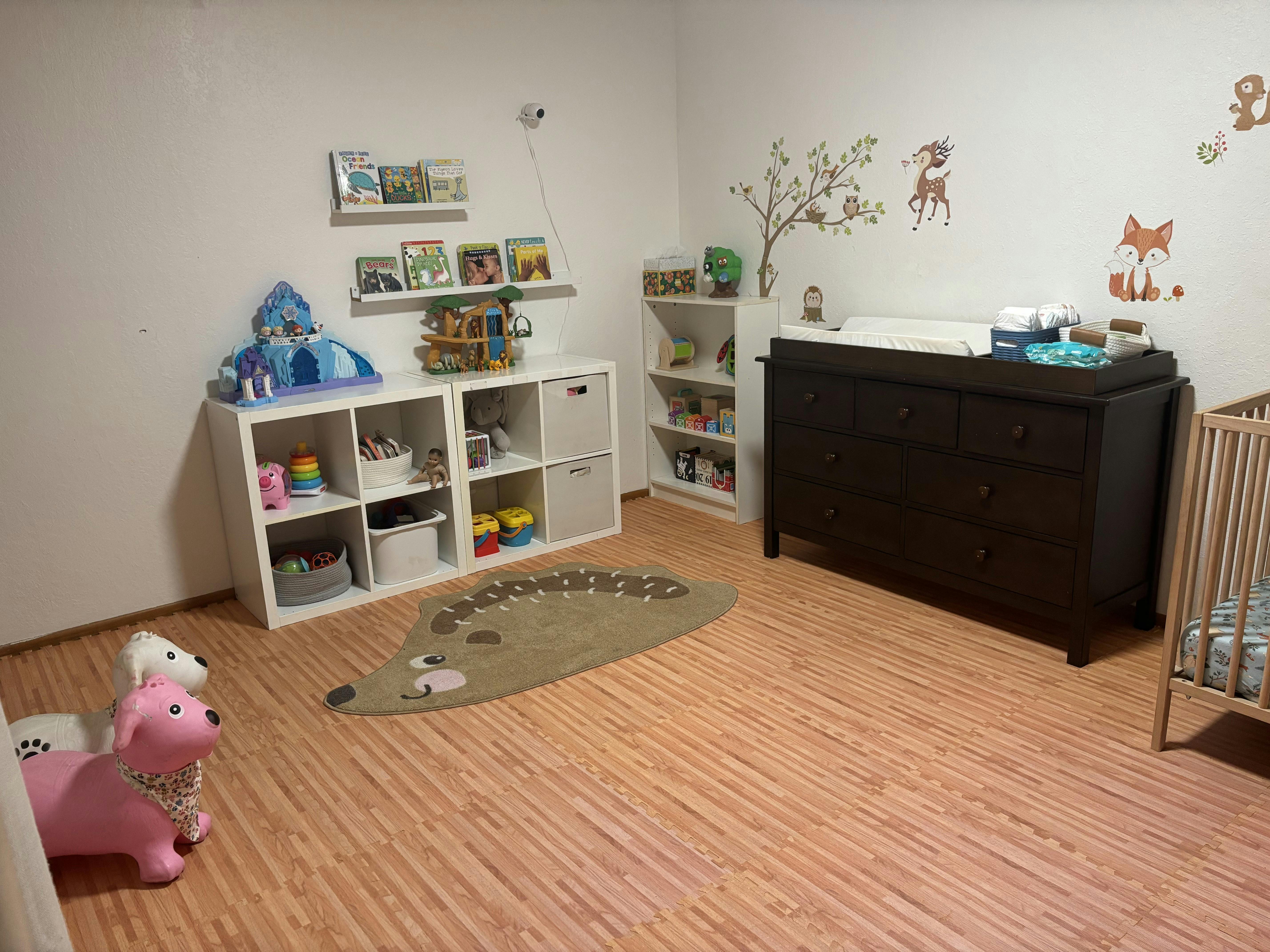 Nursery room with crib, changing table, and toy storage shelves