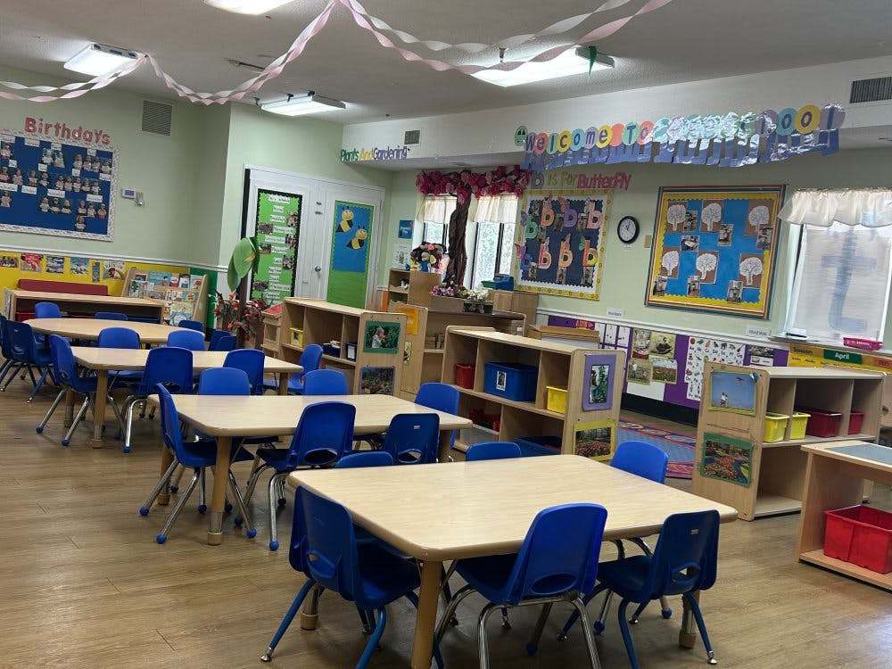 Classroom with small tables and chairs, and decorations on the walls