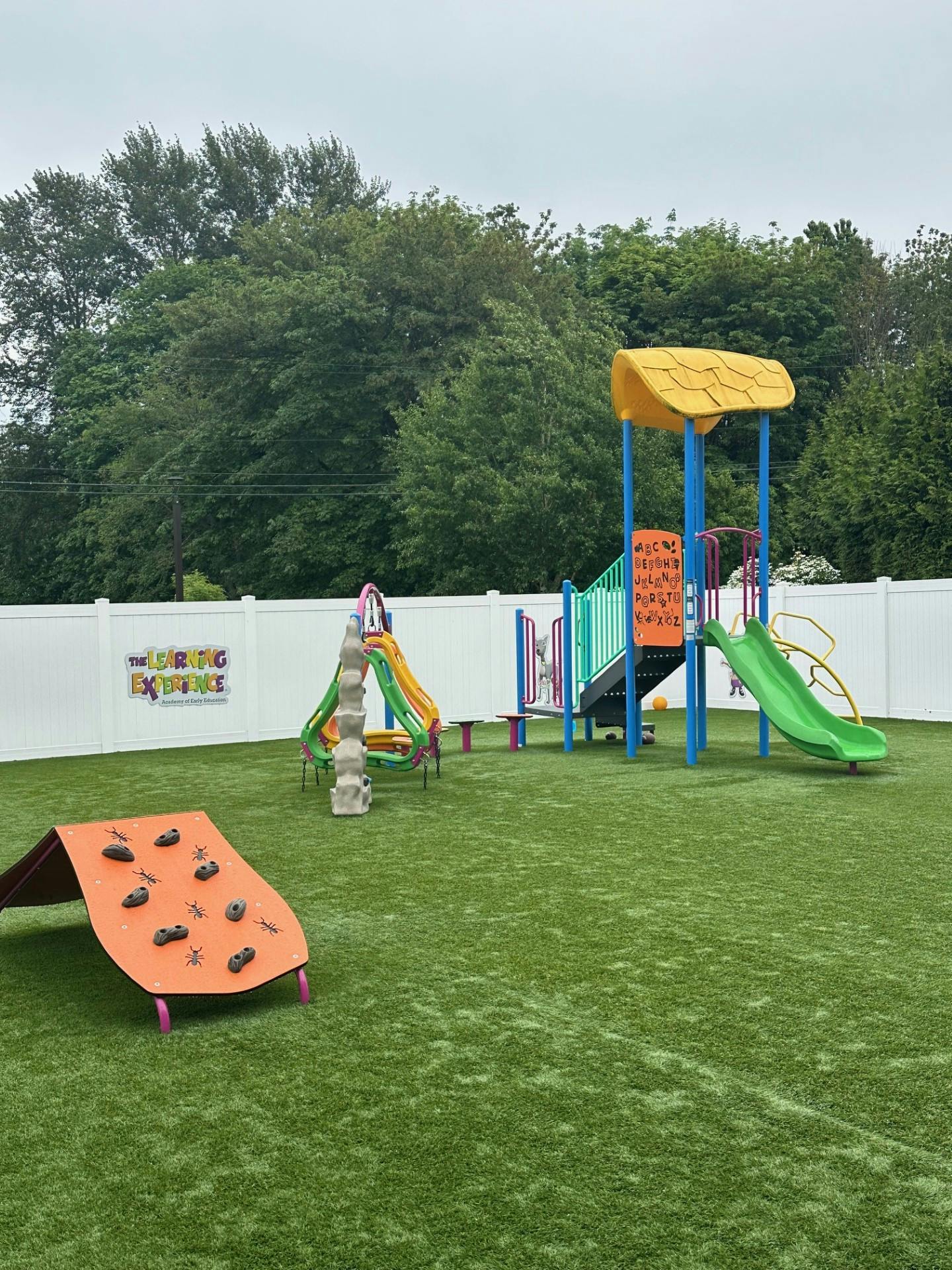 Playground with slides, climbing structures, and artificial turf