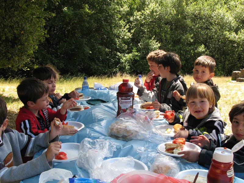 Children eating at a picnic table outdoors