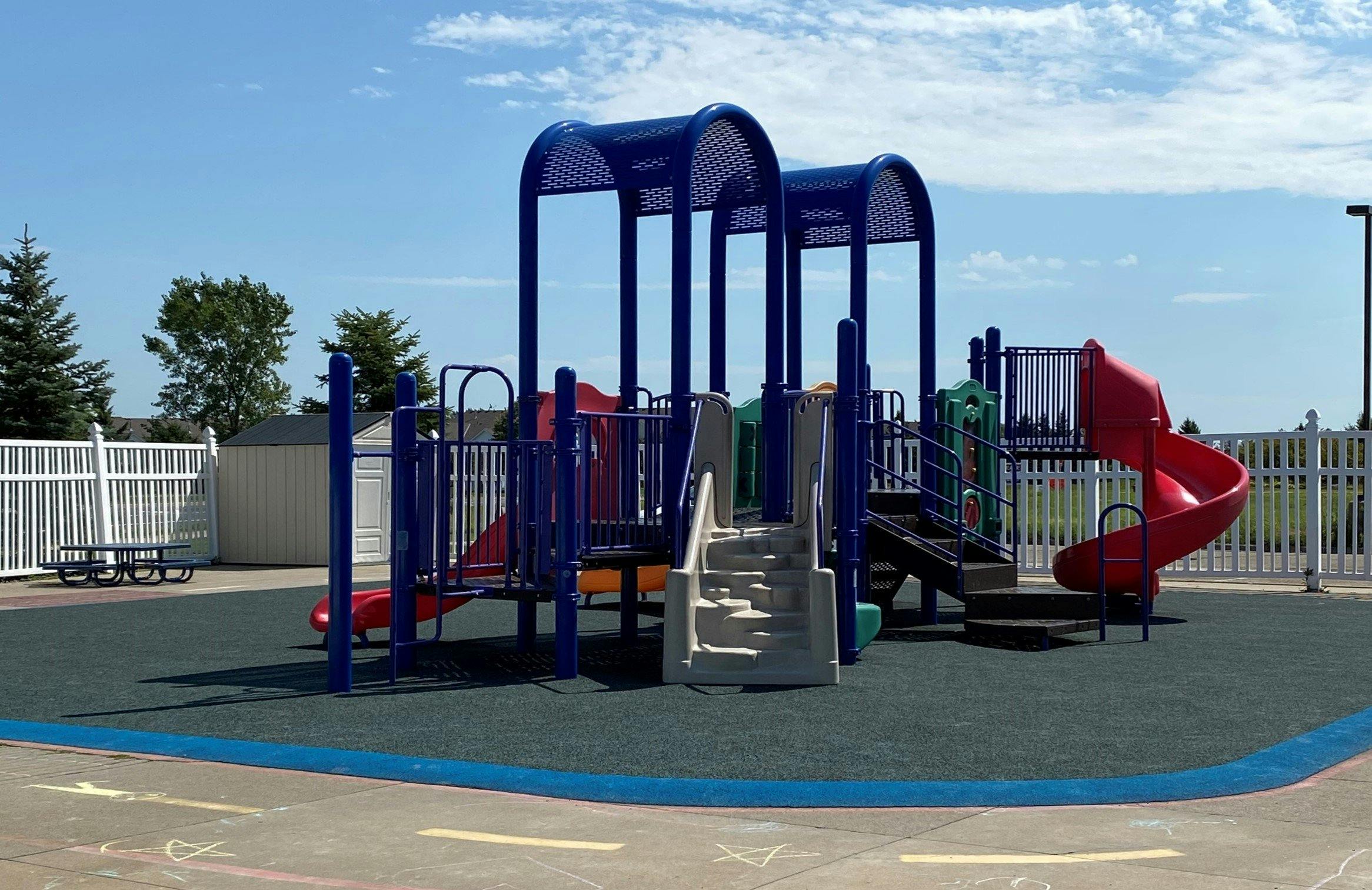 Playground with blue and red equipment, including slides and climbers