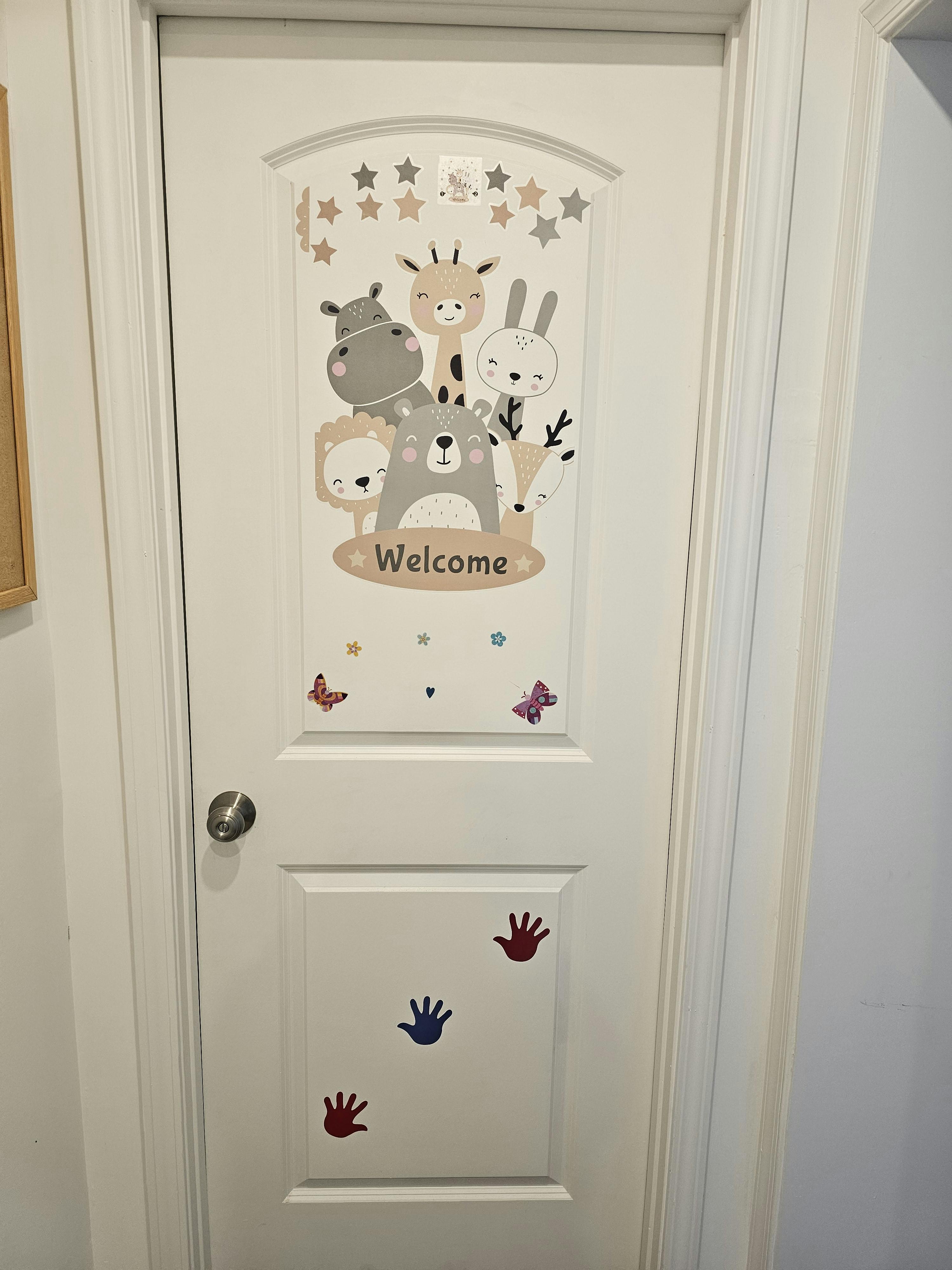 White door decorated with animal stickers and the word Welcome