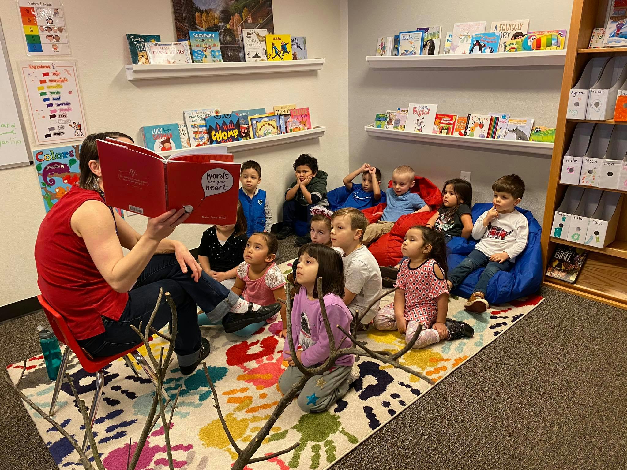 Person reading a book to a group of children in a classroom