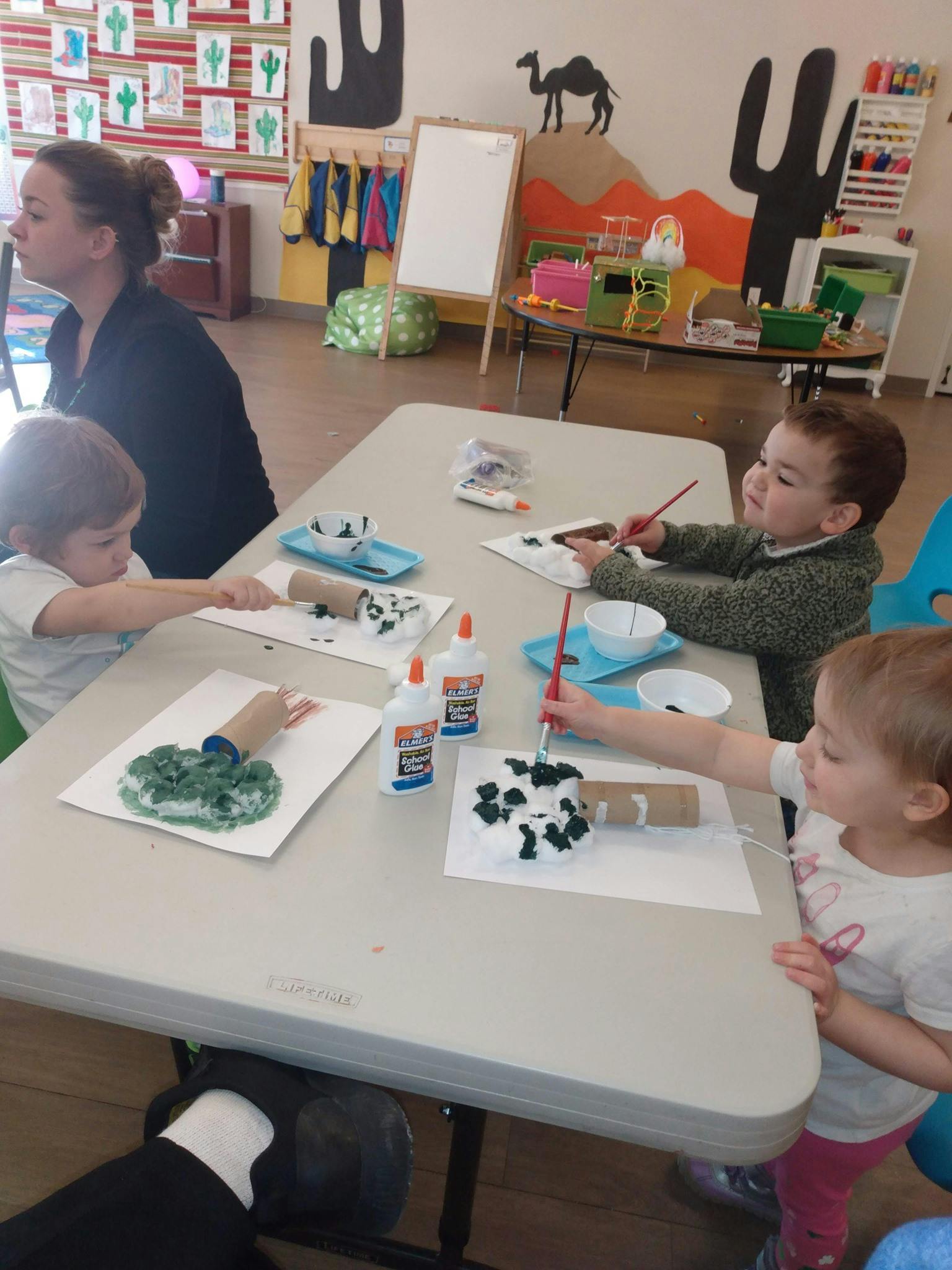 Adult and three children doing crafts at a table