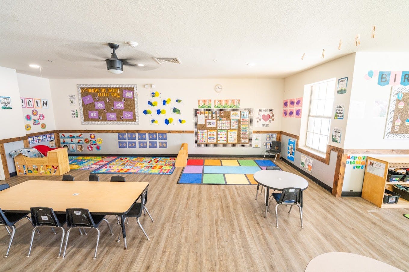 Colorful classroom interior with tables, chairs, and educational wall displays