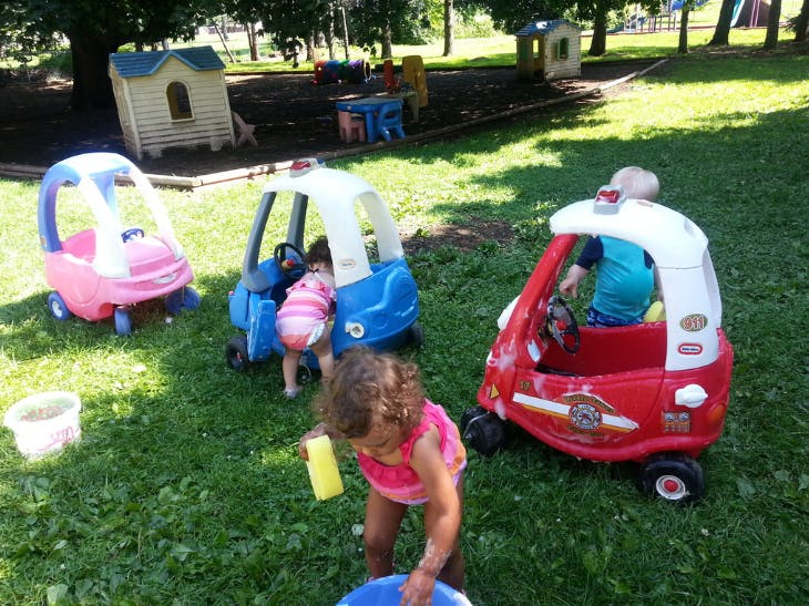 Children playing with toy cars outdoors