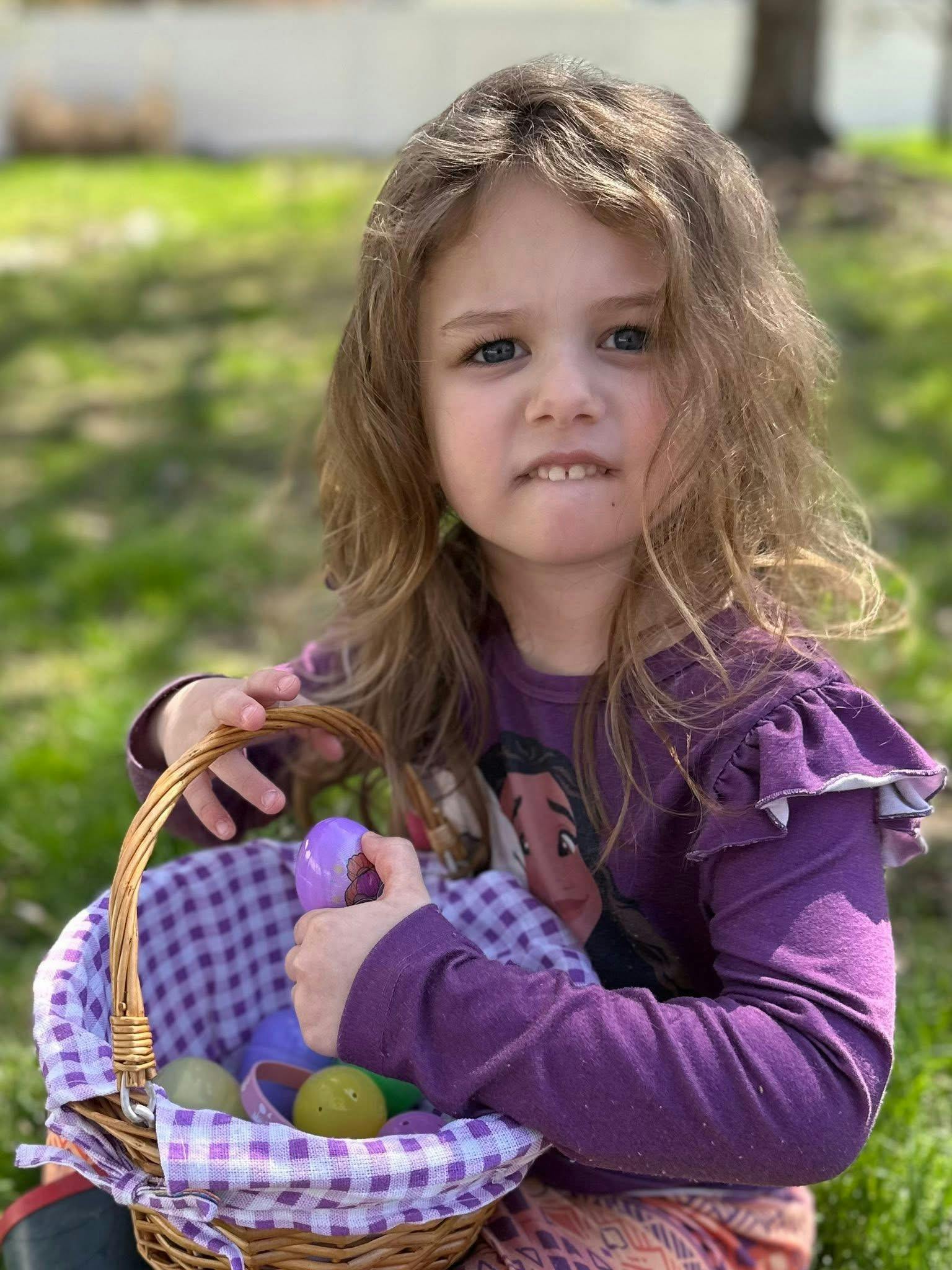 Child holding a basket with colorful eggs