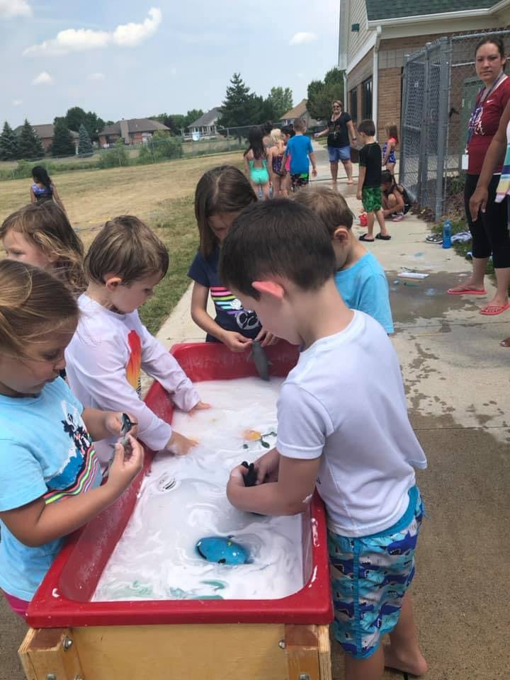 Children playing at a water table outdoors