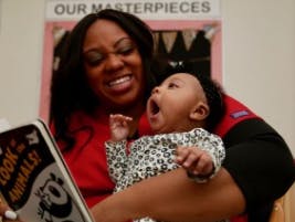 Person holding a baby who is yawning