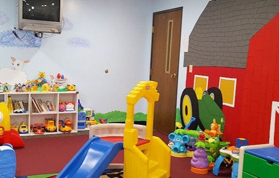 Indoor play area with slides, toys, and a barn-shaped cutout