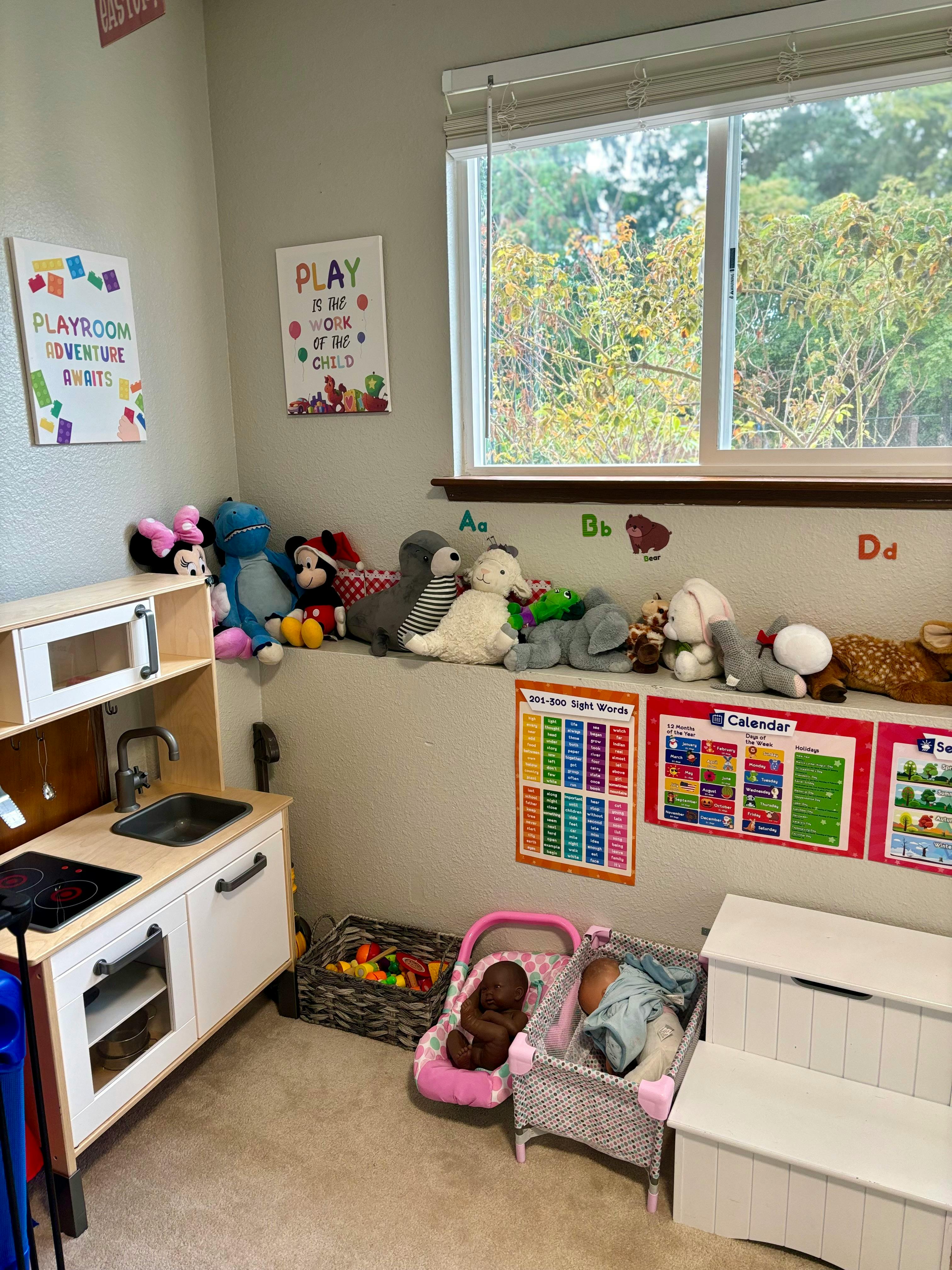 Playroom with toy kitchen, stuffed animals, and window
